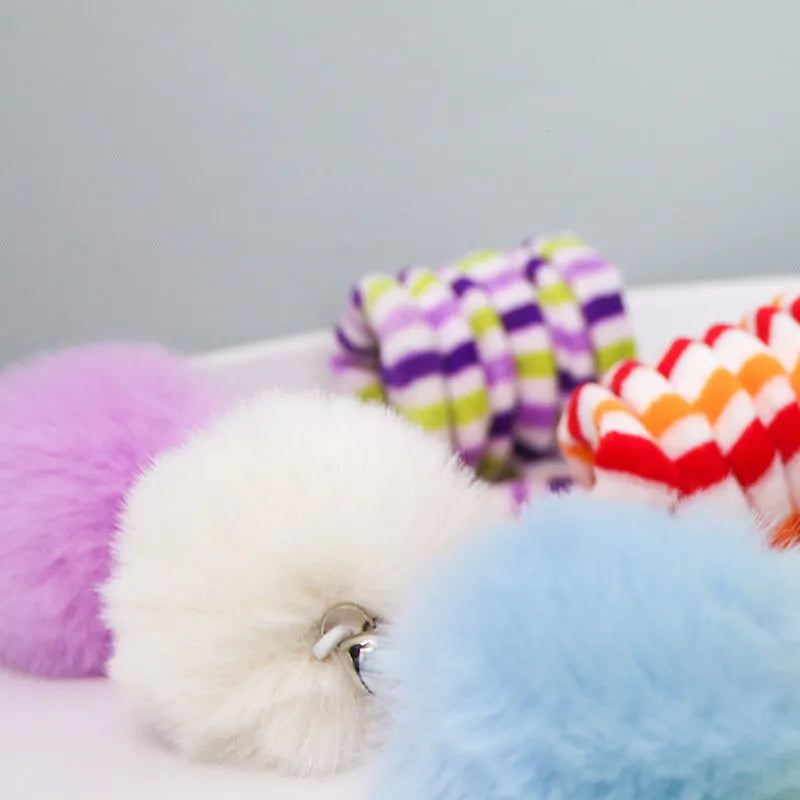 Colourful spring-mounted cat toy with an inflatable ball and bell, shown with a suction cup for hanging.