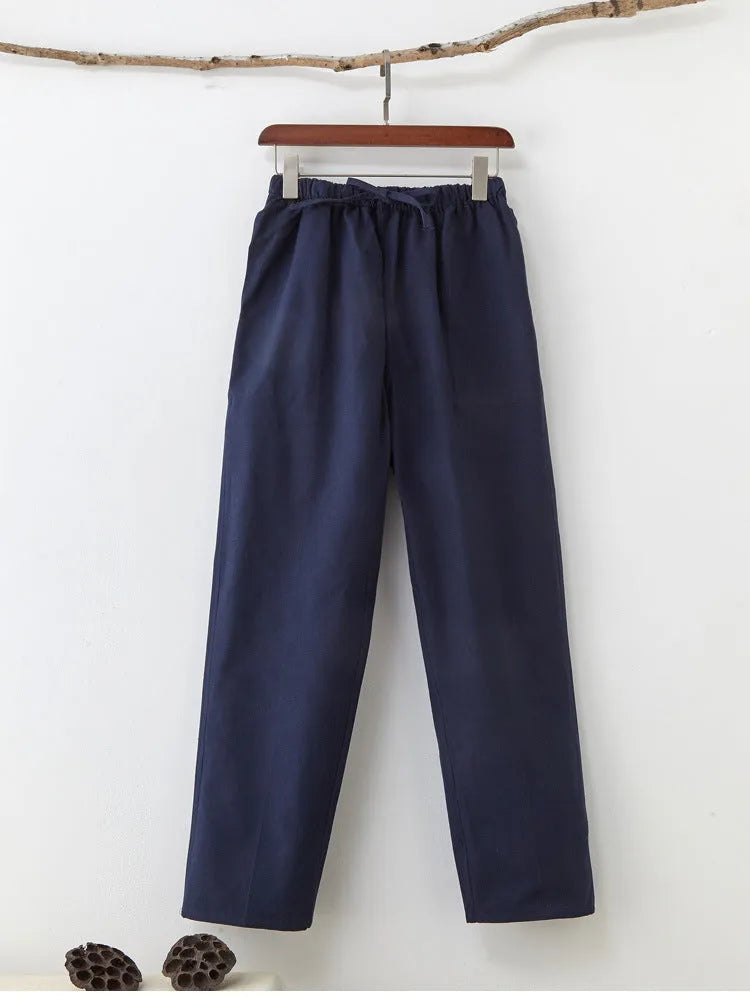 Man wearing beige pure cotton casual trousers with a drawstring waist and belt.