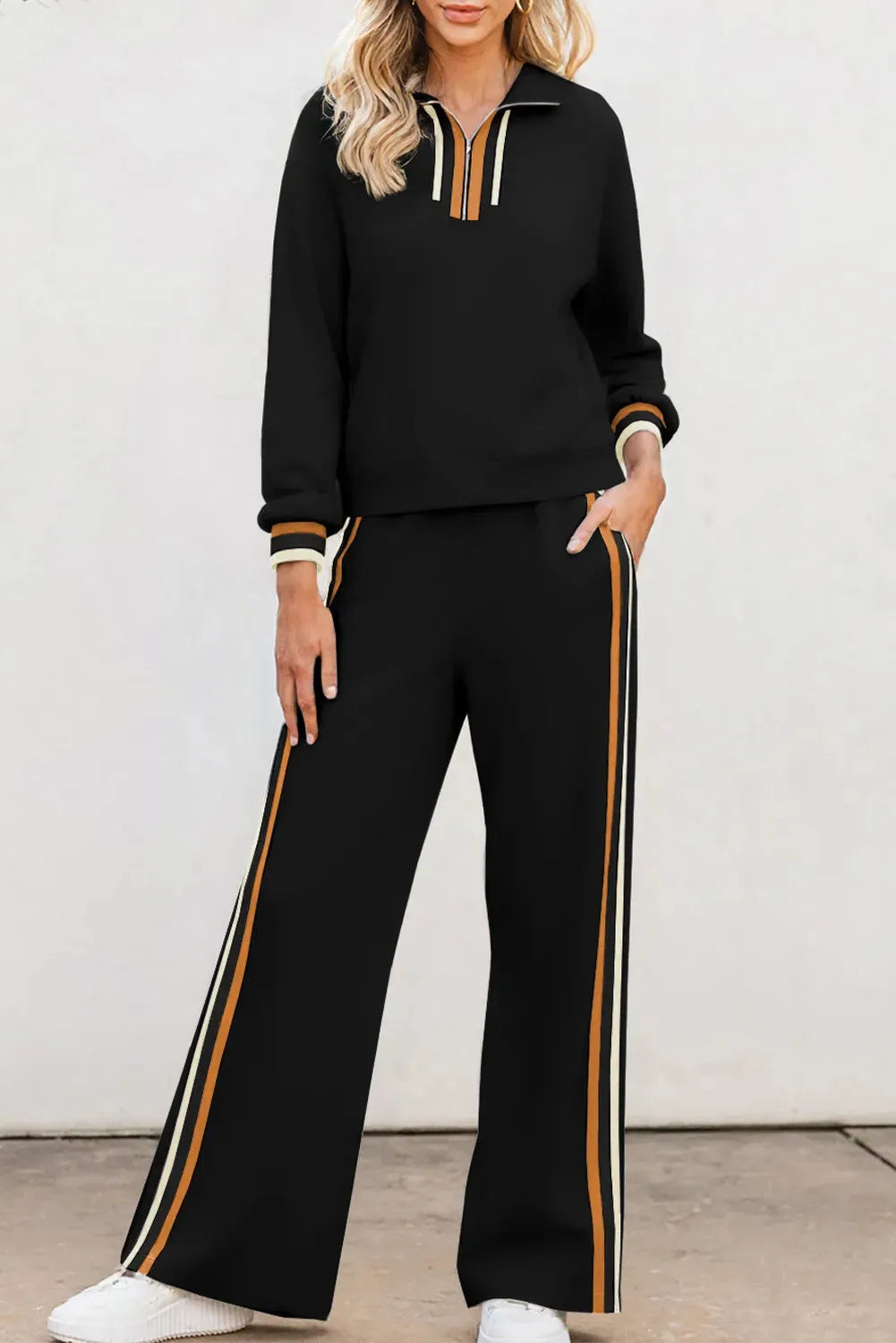 Black striped patchwork quarter zip pullover and loose pant set on a plain background