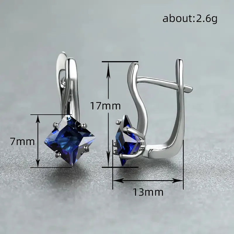 A pair of copper diamond-shaped earrings with inlaid zircon stones, shown in blue, green, and colour variants.