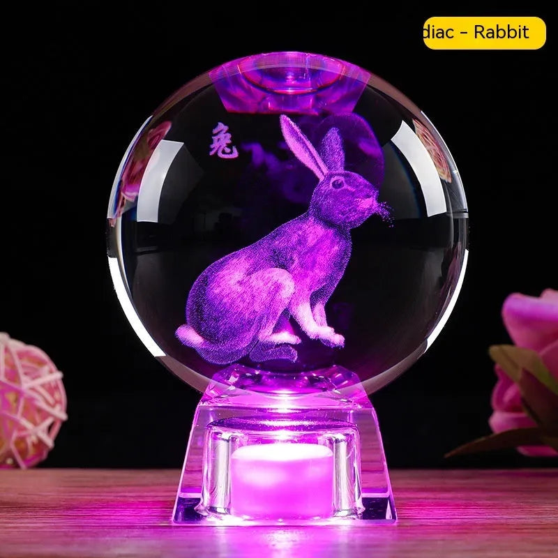 White crystal ball zodiac ornament with luminous electronic base showing Chinese animal designs