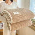 Solid colour jacquard milk velvet blanket in green on a bed with Nordic style decor