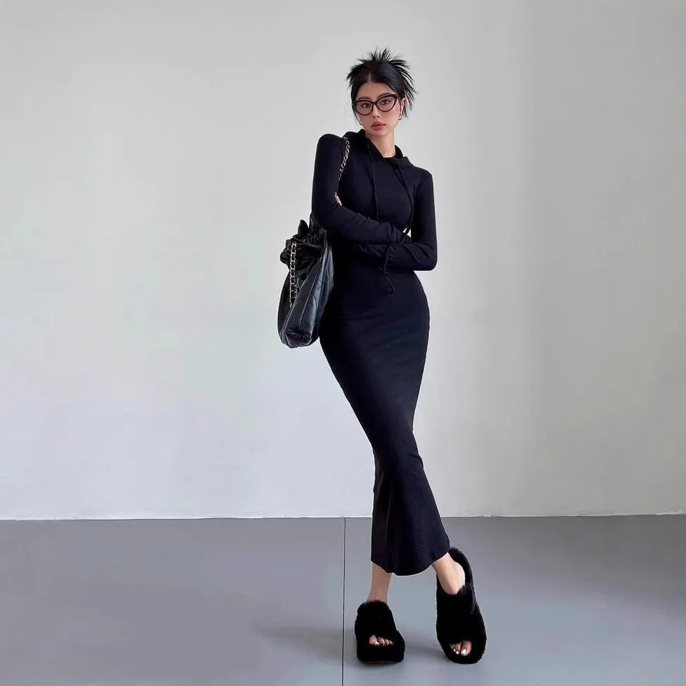 A woman's light grey hooded sheath dress with long sleeves, high waist, and over-the-knee length.