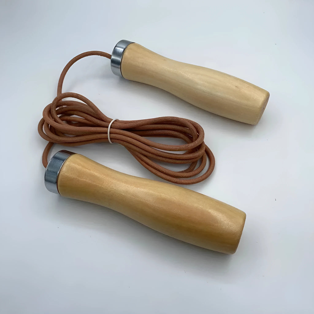 Real cowhide leather jump rope with solid wood handles and denim grip on grey background