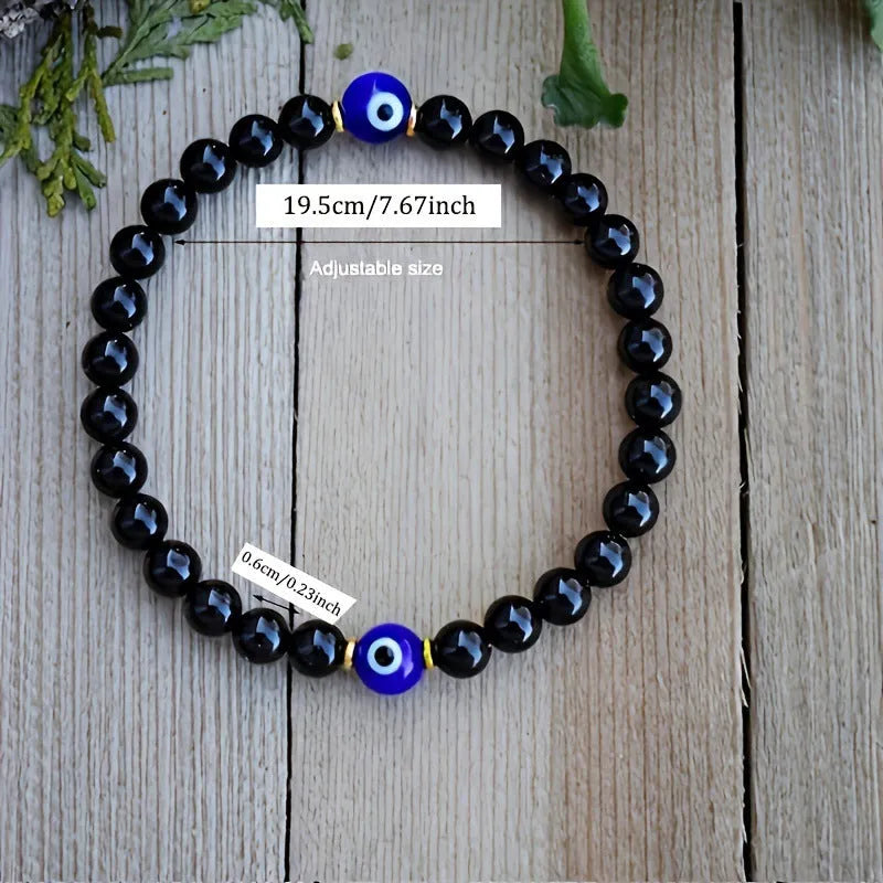 Men's black 8mm devil's eye obsidian beaded bracelet with geometric pattern on table