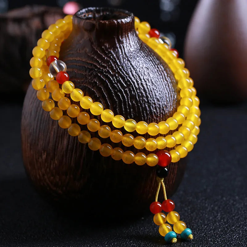 Women's geometric crystal necklace with lucky cat charm alongside 108 agate and canary stone beads