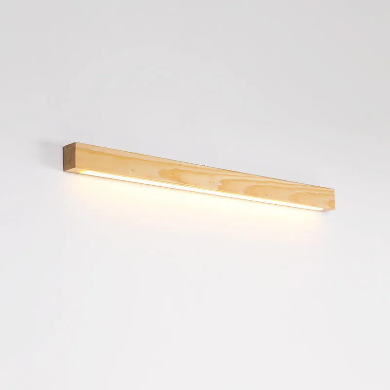 Long, slim walnut-coloured wooden wall lamp with integrated LED light, shown in a minimalist room setting.