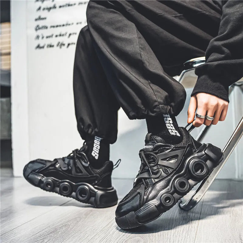 Men's black mesh sneakers with thick rubber sole, round toe, lace-up front, and abstract pattern