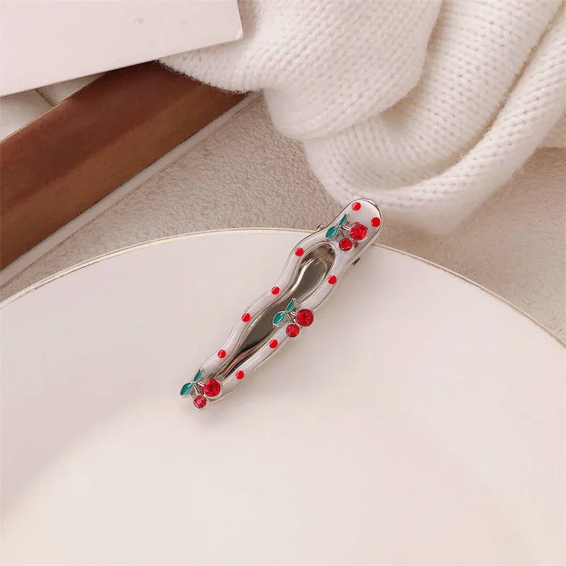 Red love heart-shaped plastic hair clip with retro dots and a willow leaf silhouette on a white background.