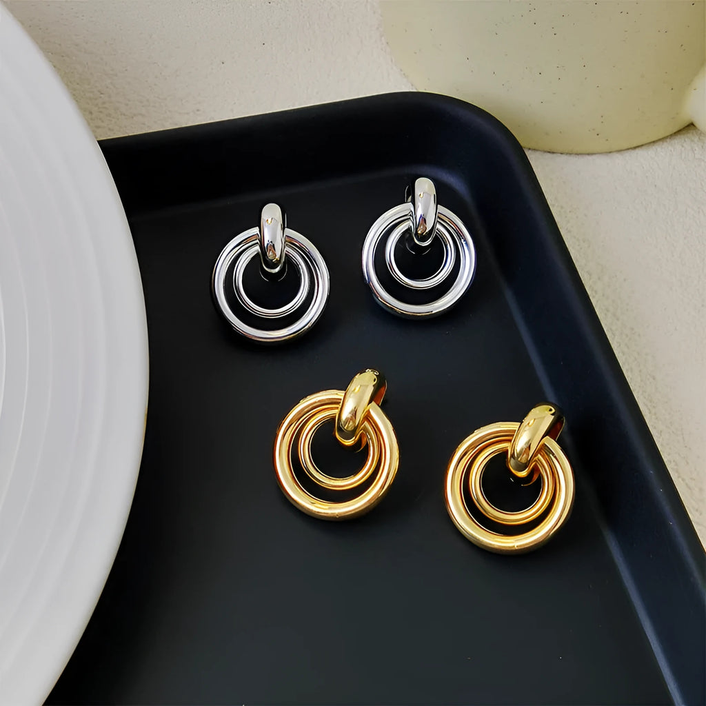 A pair of women's geometric round ring earrings with an irregular shape in a gold electroplated finish.