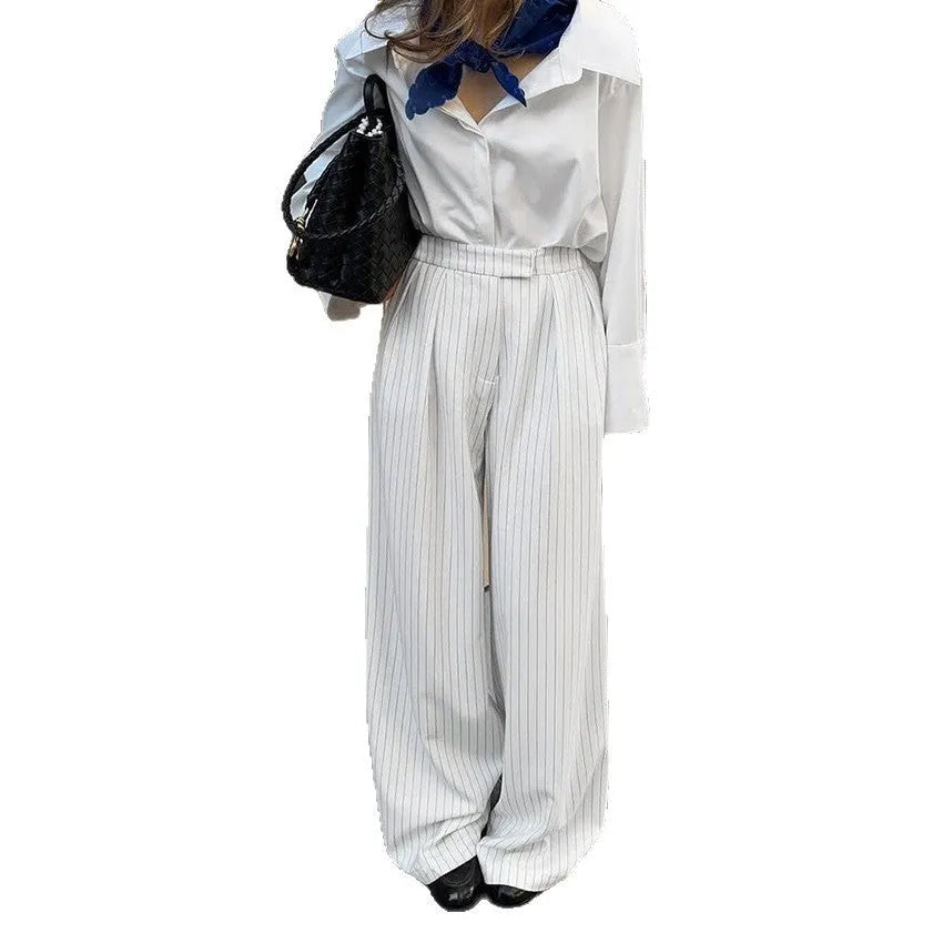 White striped wide-leg casual trousers with a zipper fastening on a neutral background.