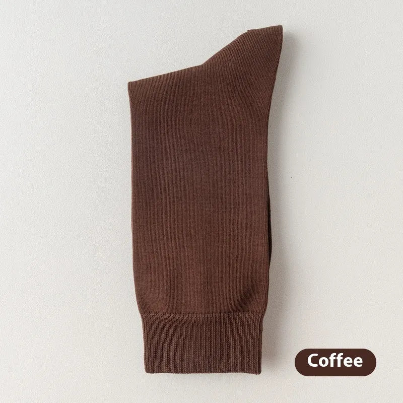 Five pairs of men's solid colour mid-calf socks made from combed cotton, shown in assorted shades.