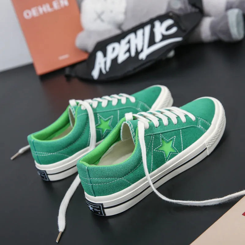 Low top board shoes with cross straps and leather stitching, available in green, black, light blue, grey, ink blue