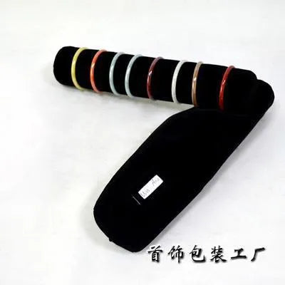 Portable bracelet watch storage bag in black leather with black bracelet stick on a flat surface