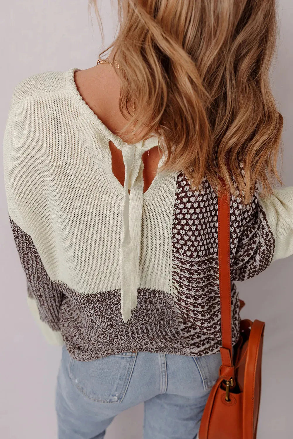 Dark khaki loose fit sweater showing back tie detail on colour block panel.
