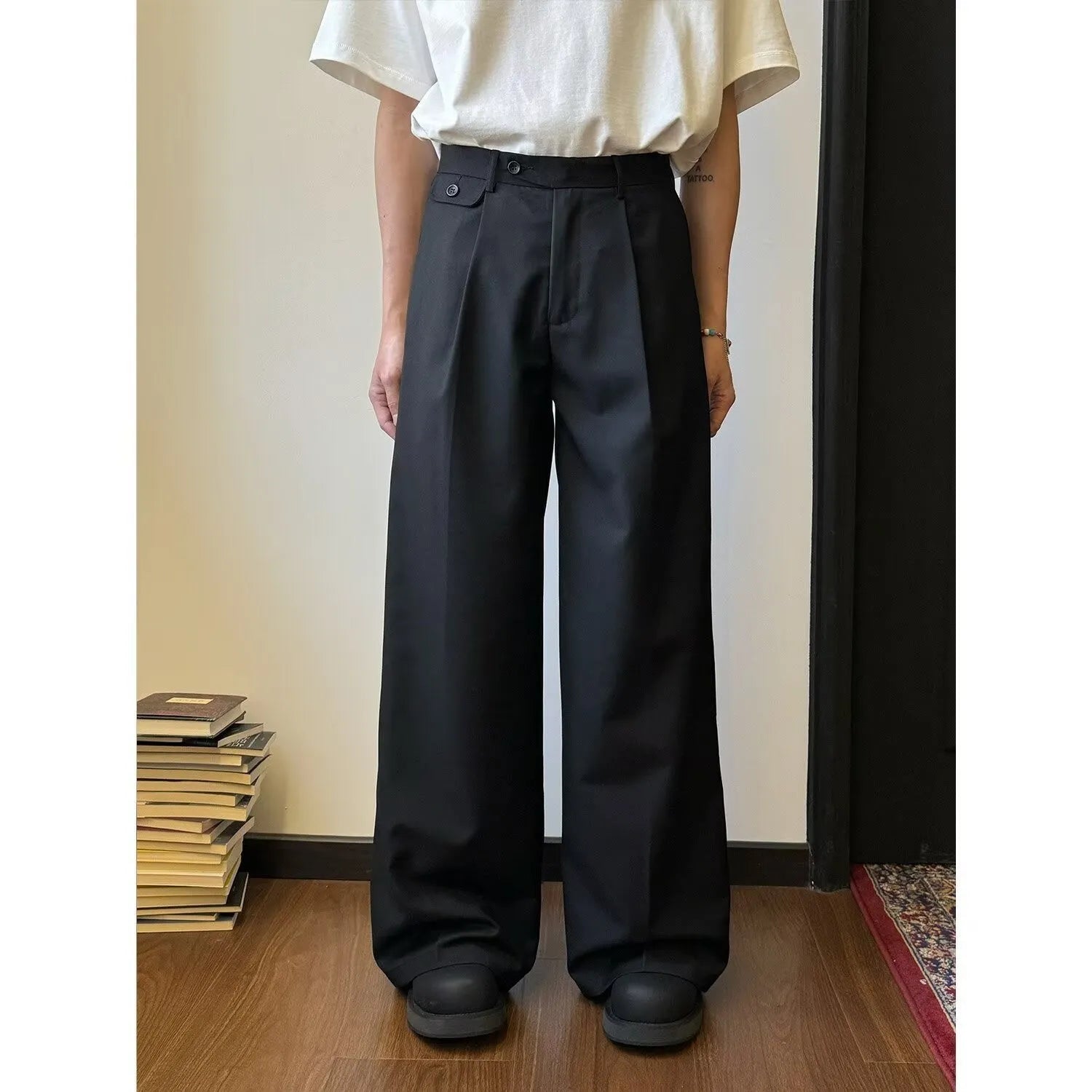 Men's straight-leg wide trousers in brown and black, showing loose fit and casual style.