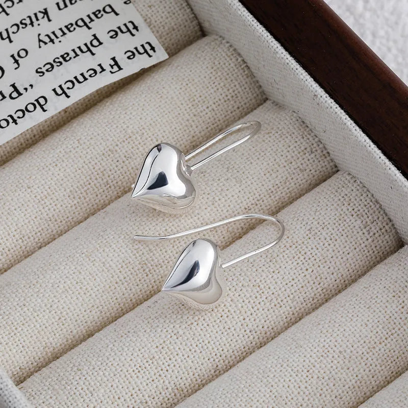 Silver heart-shaped women's earrings with glossy finish and three-dimensional design
