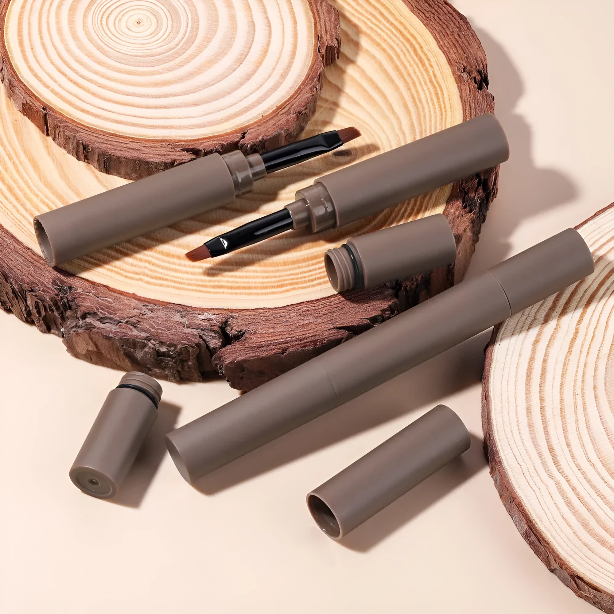 Double-headed eyebrow cream tube with dual applicator shown in five colour shades.