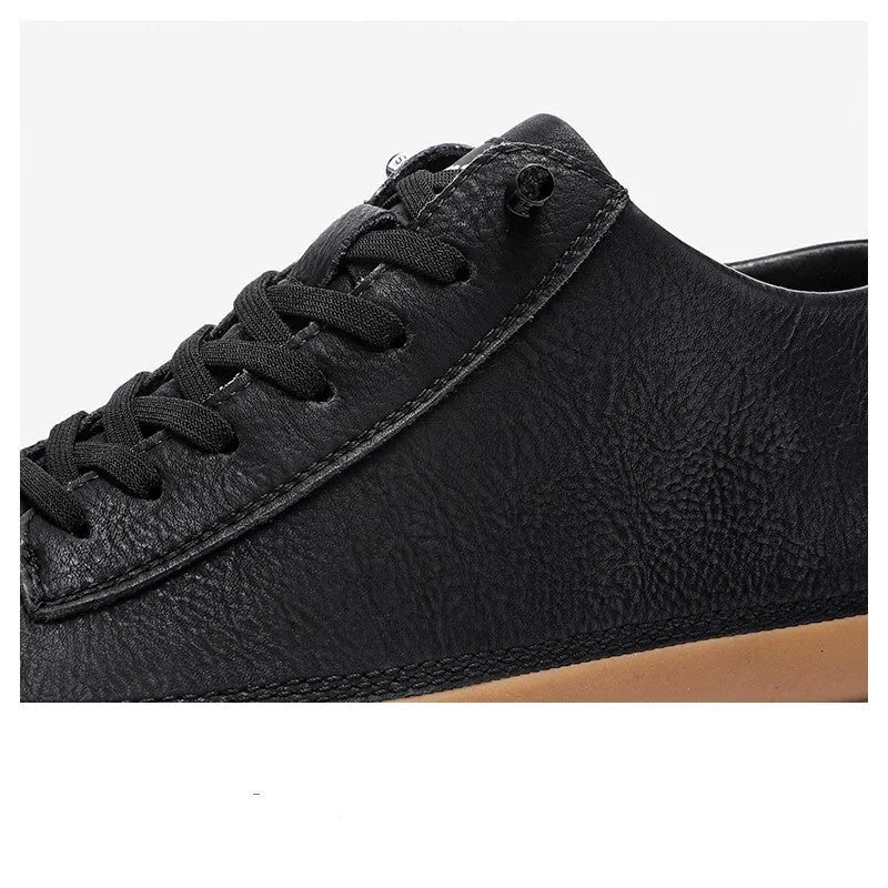 Men's black leather casual shoes with a round toe and white rubber sole on a plain background.