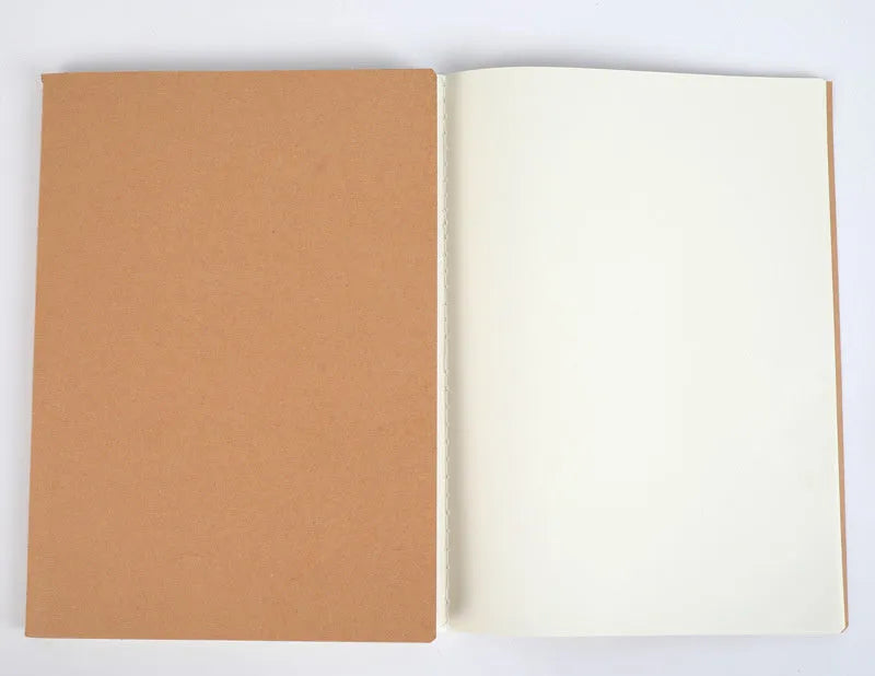 Softcover thread-bound notebook open on a table, showing flat-lay binding and lined paper.