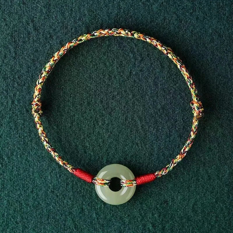 Handmade woven rope bracelet with silver peace buckle clasp on colourful braided cord