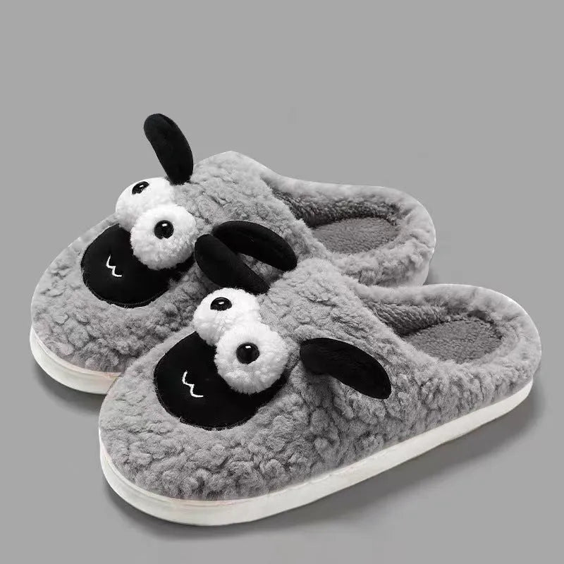 Brown suede slip-on slippers with a sewn PVC sole on a wooden floor.