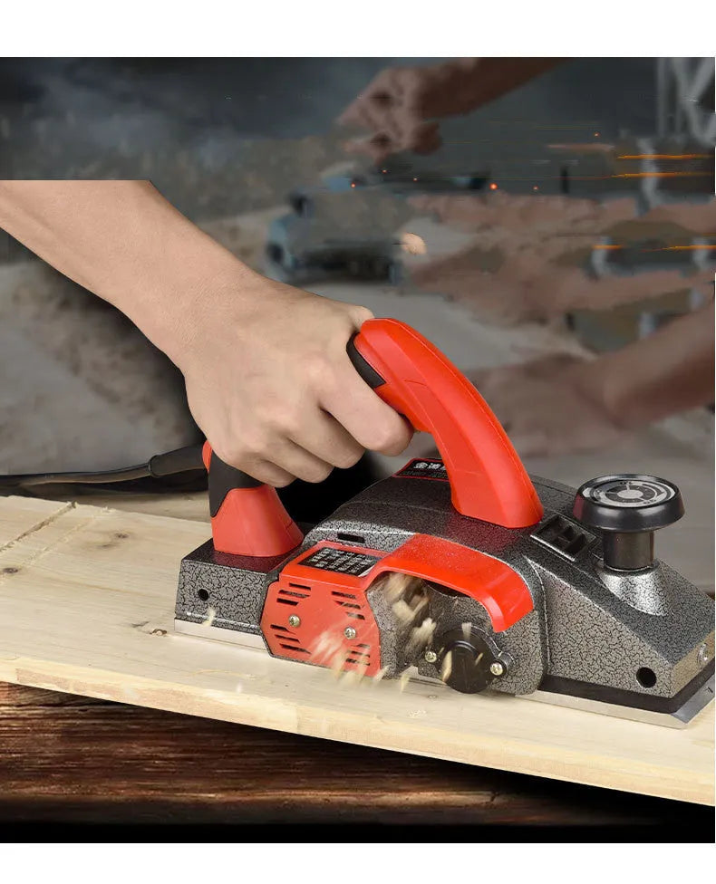Red desktop electric wood planer with aluminium body, showing 82mm planing width and depth adjustment controls