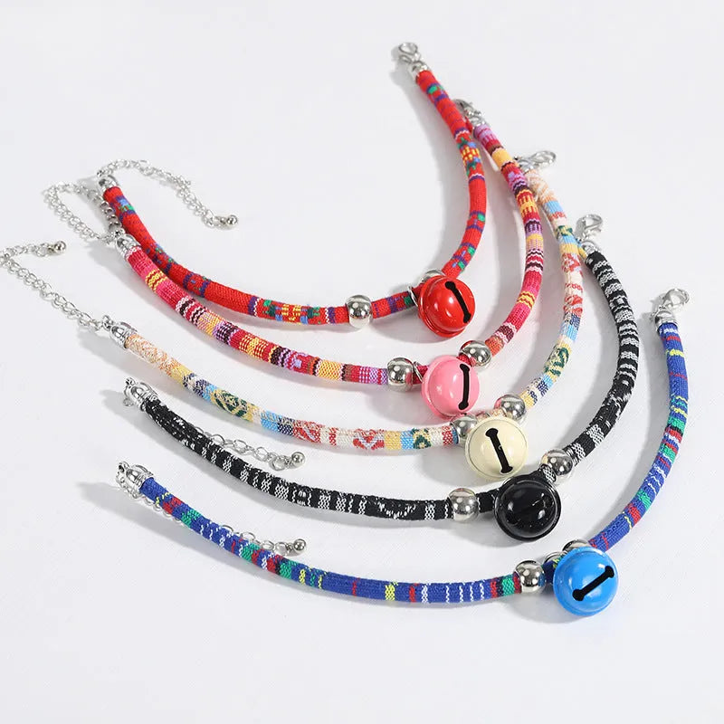 An adjustable ethnic-style pet collar with a metal buckle and bell, shown in various colours.