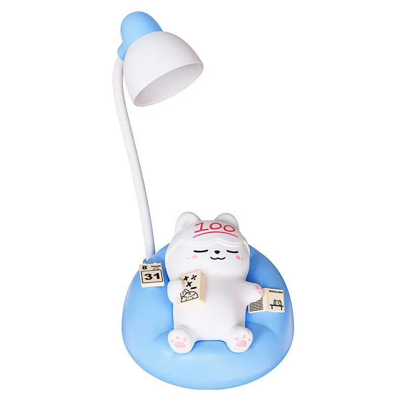 Sleeping cat shaped small night lamp in pink with USB charging cable on bedside table