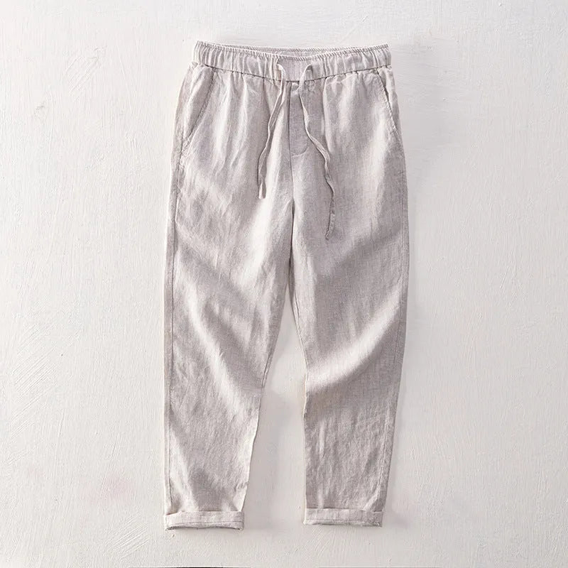Men's straight-leg linen trousers in light gray shown laid flat.