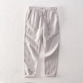 Men's straight-leg linen trousers in light gray shown laid flat.