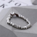 Handmade women's bracelet with irregular square design in wood and silver materials on elastic band