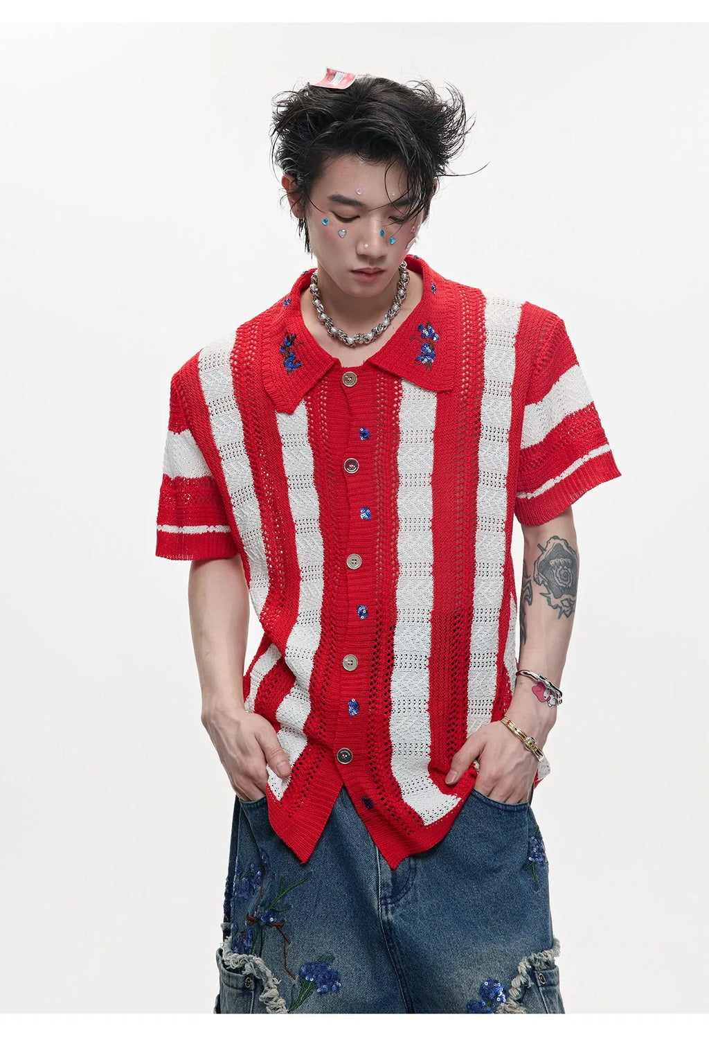 Man wearing a red and black patchwork striped retro knitted short-sleeved shirt in a loose fit.