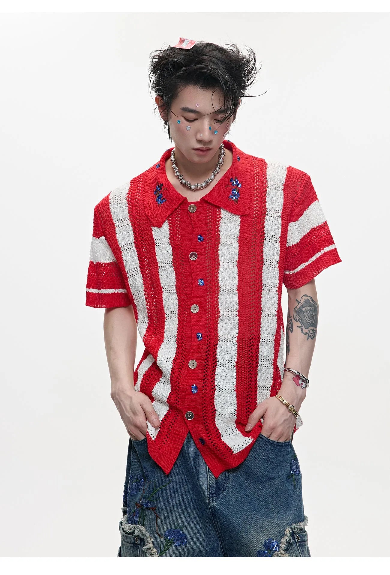 Man wearing a red and black patchwork striped retro knitted short-sleeved shirt in a loose fit.
