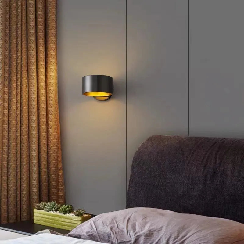 Modern minimalist copper wall lamp in gold finish mounted on a wall.