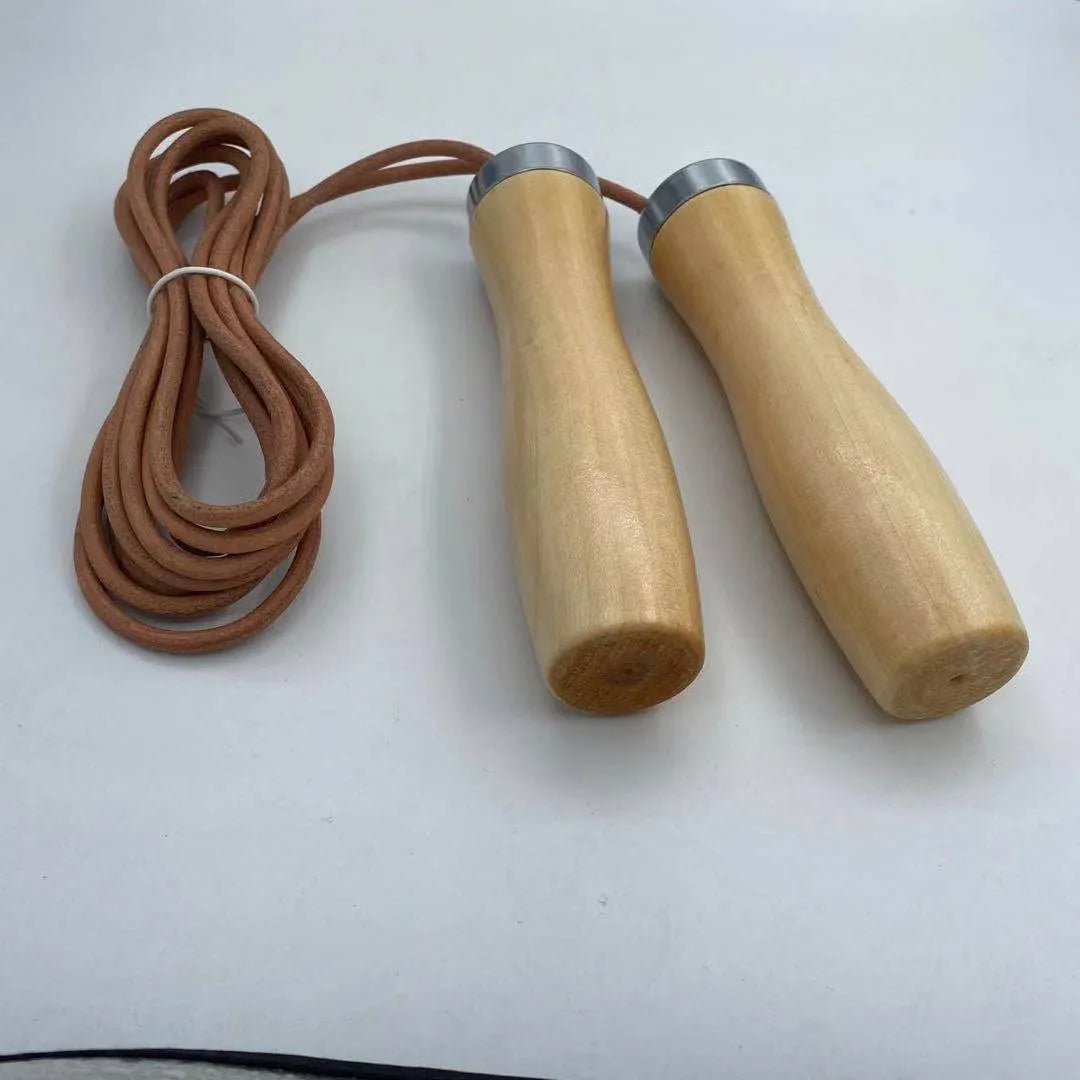 Real cowhide leather jump rope with solid wood handles and denim grip on grey background