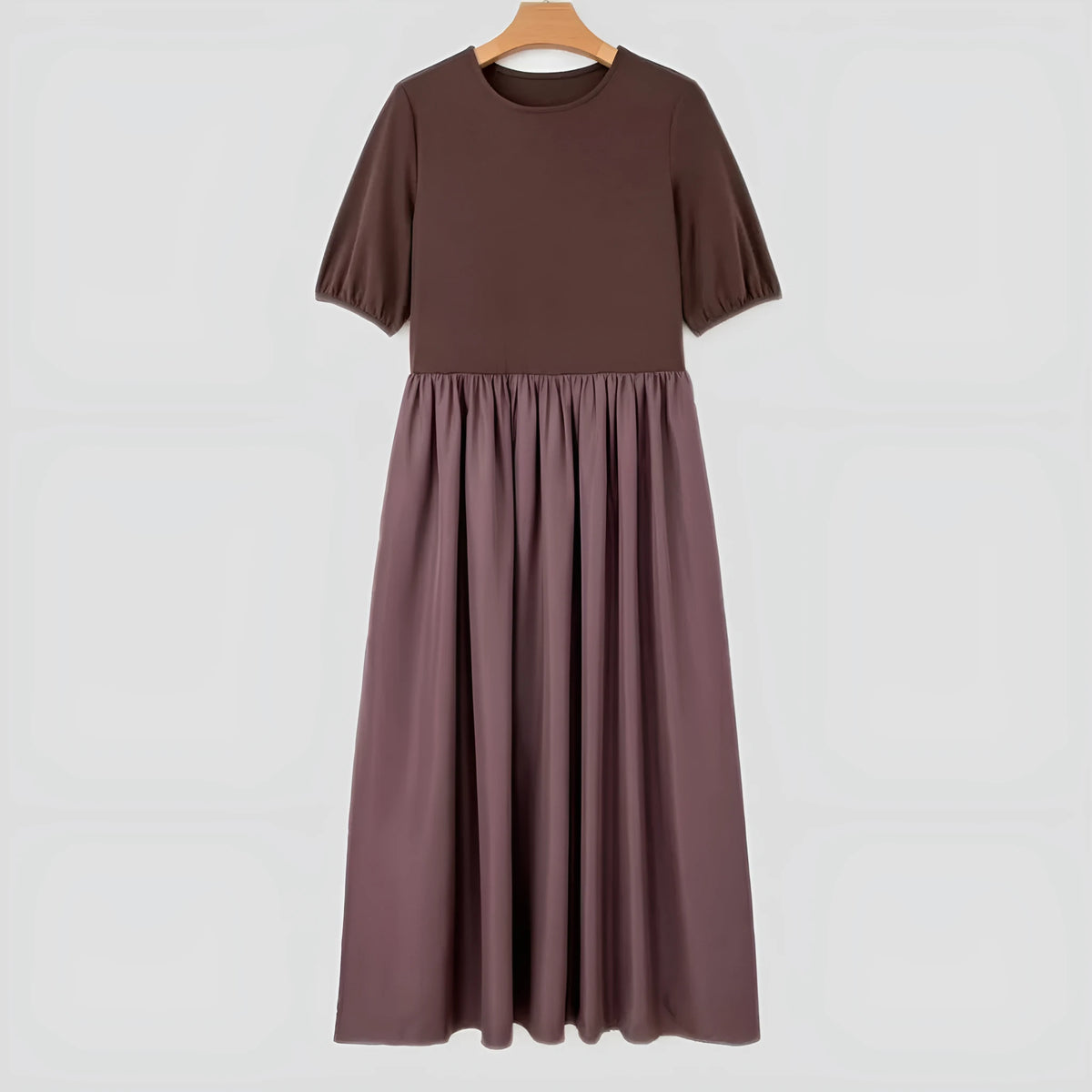 Woman wearing a coffee-coloured knitted patchwork dress with high waist and short sleeves