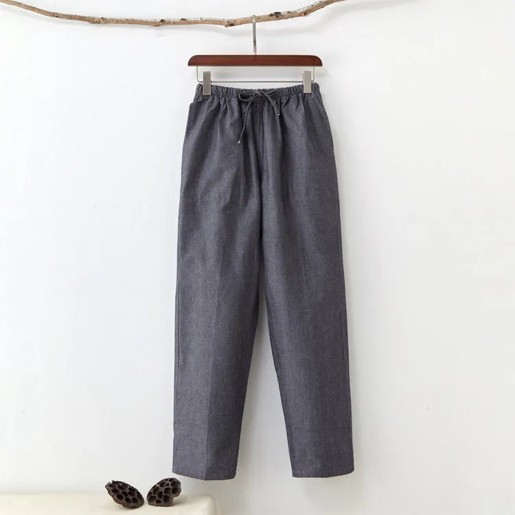 Man wearing beige pure cotton casual trousers with a drawstring waist and belt.