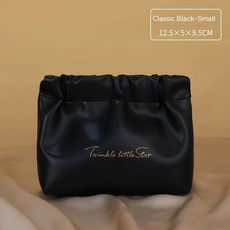 PU leather travel toiletry bag in classic black colour, showing large capacity and zipped compartments.