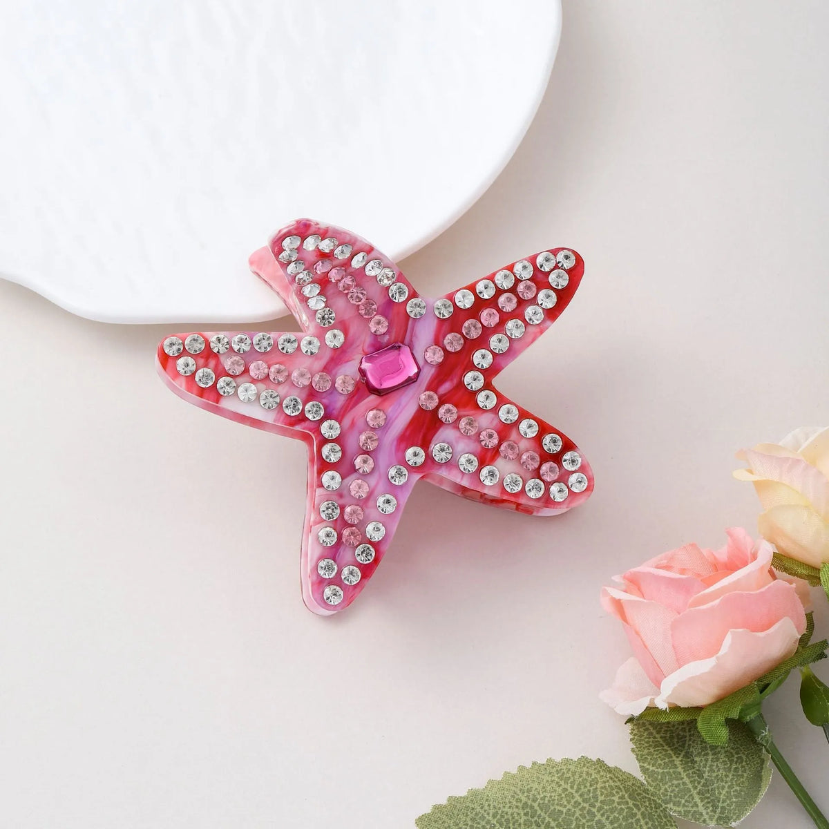 Blue acrylic starfish hairpin with diamond-encrusted surface on white background