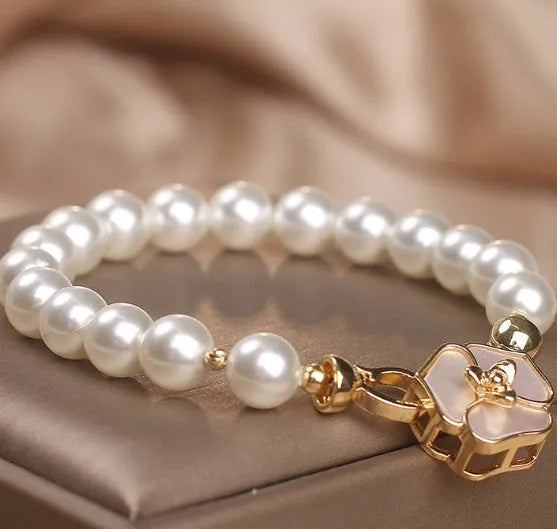 White imitation pearl bracelet with floral French-style design on display for women