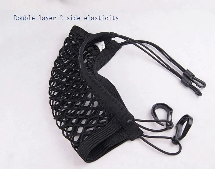 Black elastic nylon car pet fence isolation net installed on middle seat with hooks.