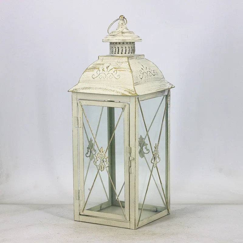 European wrought iron storm lantern with tempered glass in black or white gold finish, shown in small, medium, and large sizes.