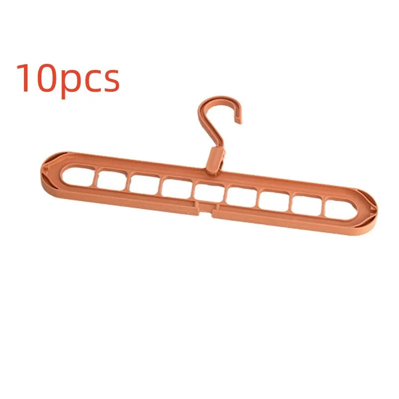 Green plastic nine-hole multifunctional clothes hanger for trousers on a white background.