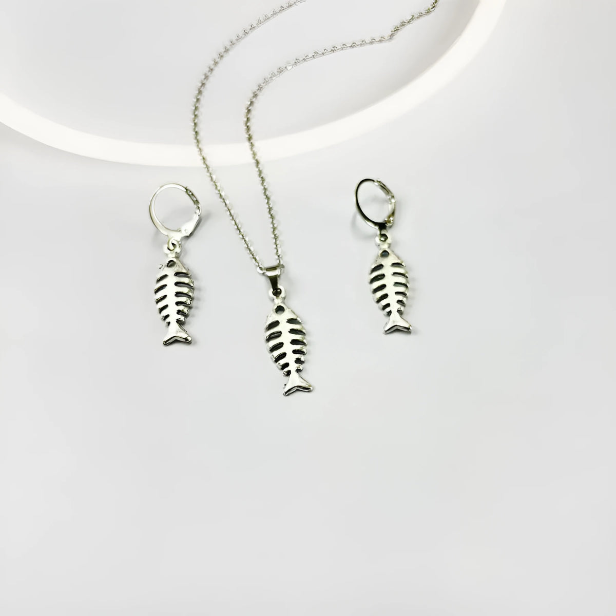 Retro fishbone pendant necklace and earrings set with adjustable alloy chain on a white background