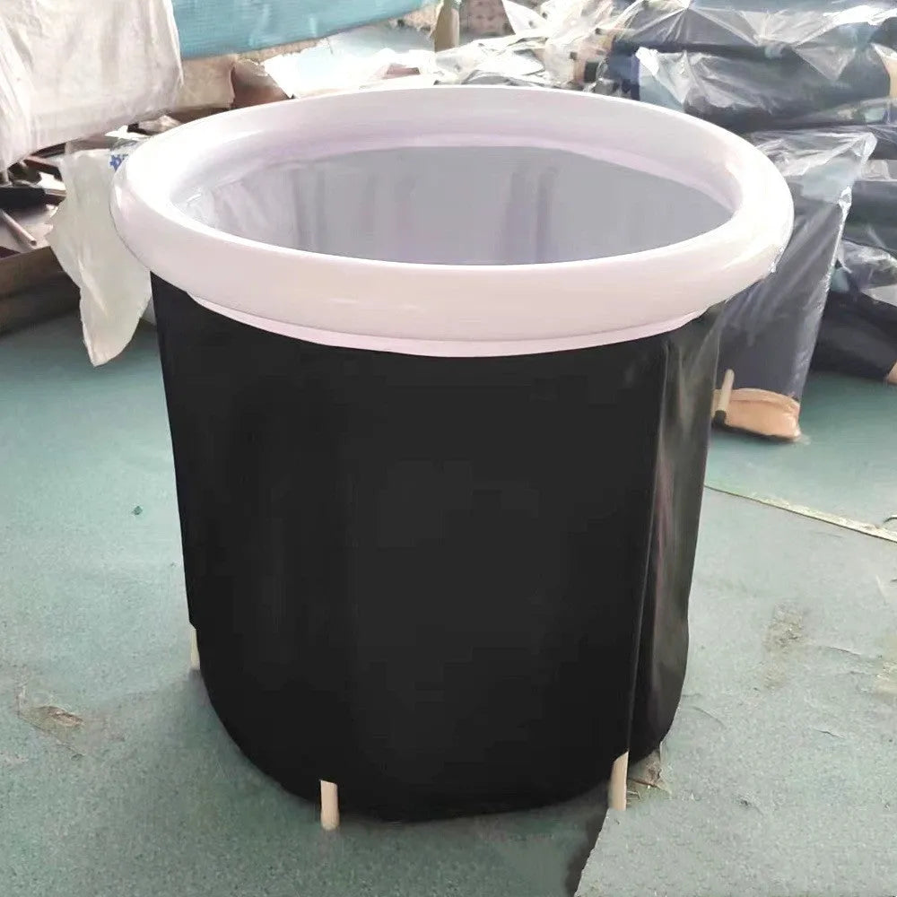 Black inflatable portable ice bath tub with weather lid, shown outdoors.