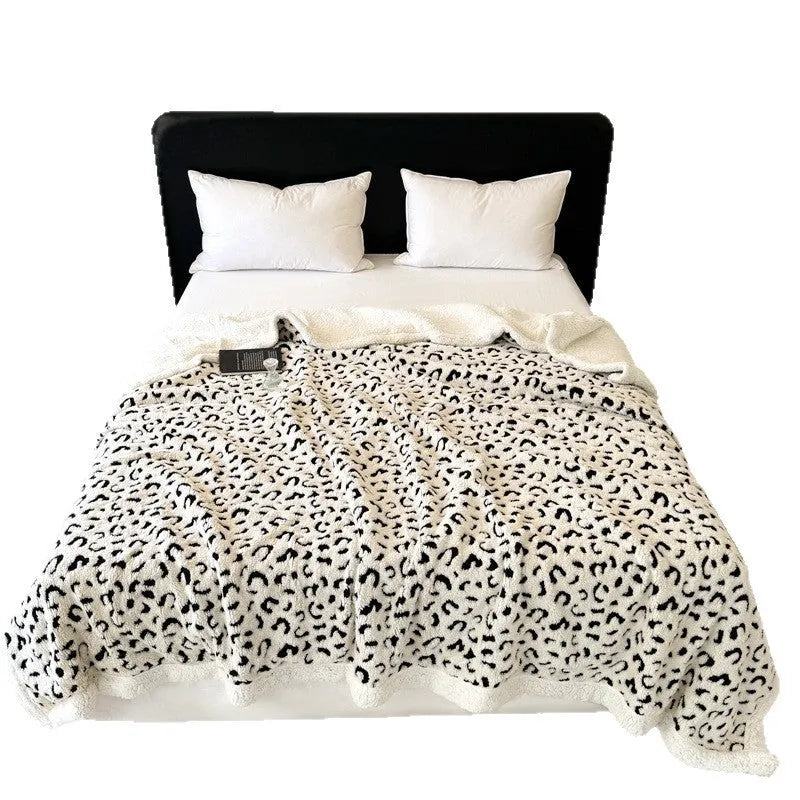 Double-layer taffeta blanket with woven leopard print pattern draped over sofa