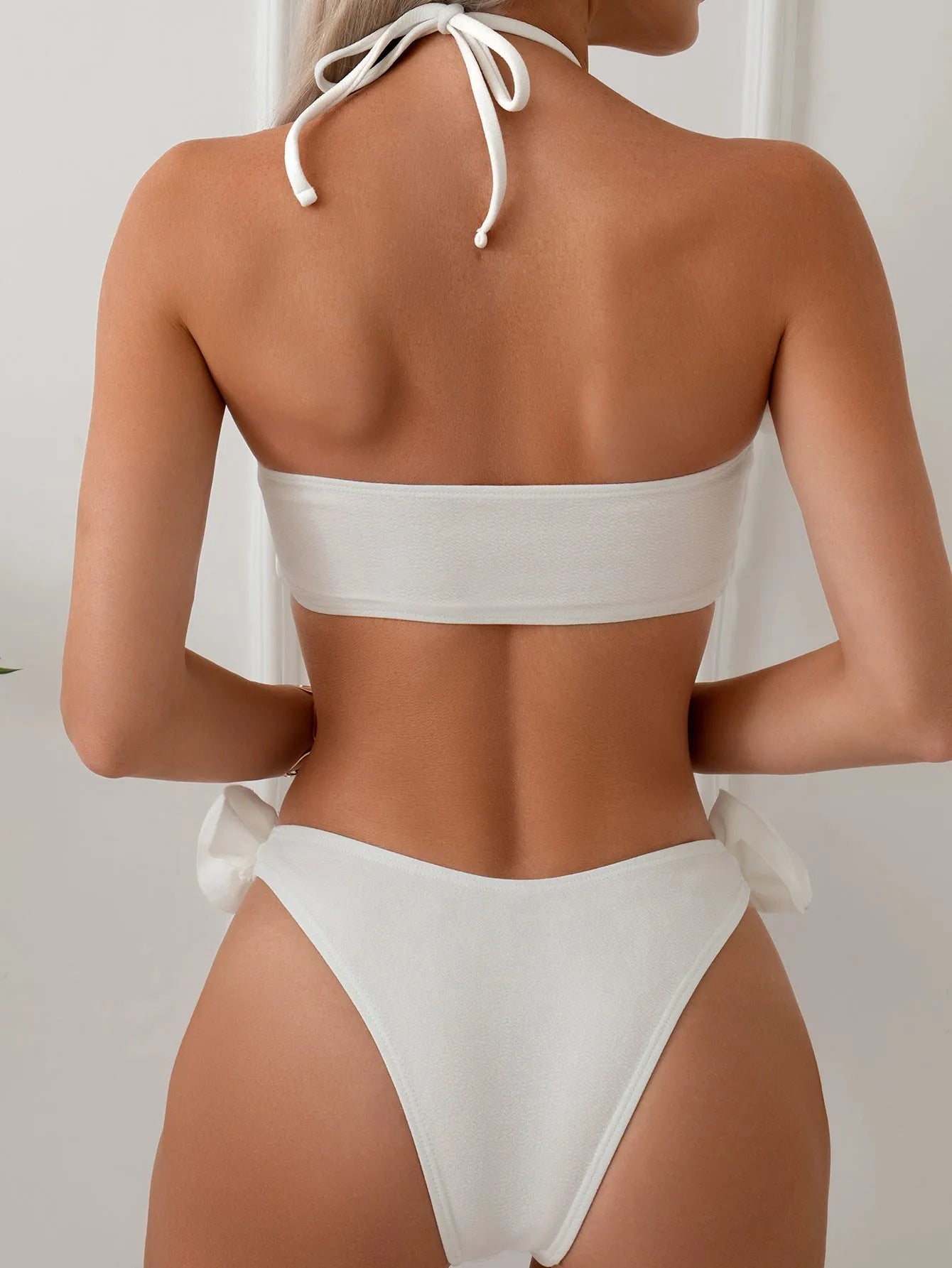 White halter swimsuit with three-dimensional floral lace-up front and split sides