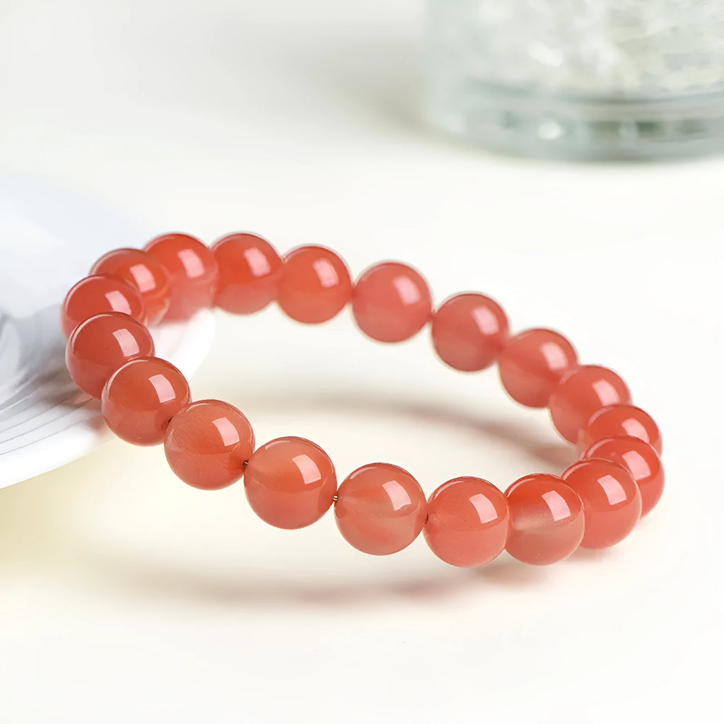 Natural South Cherry Red Agate bracelet with polished beads on an elasticated cord.
