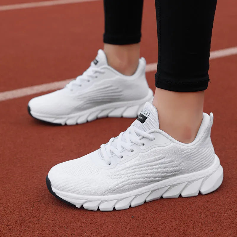 Women's low-top platform running sneakers in black and white colours with round toe and cross strap design